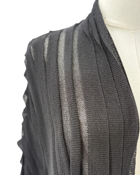 black cardigan draped over a mannequin on a white background