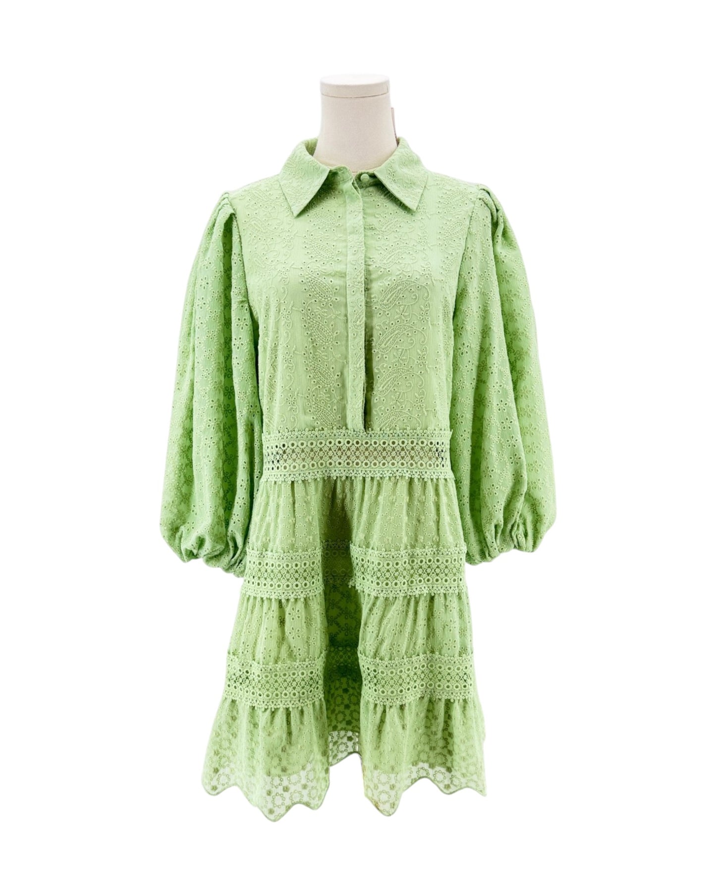 Green dress on a mannequin against a white background