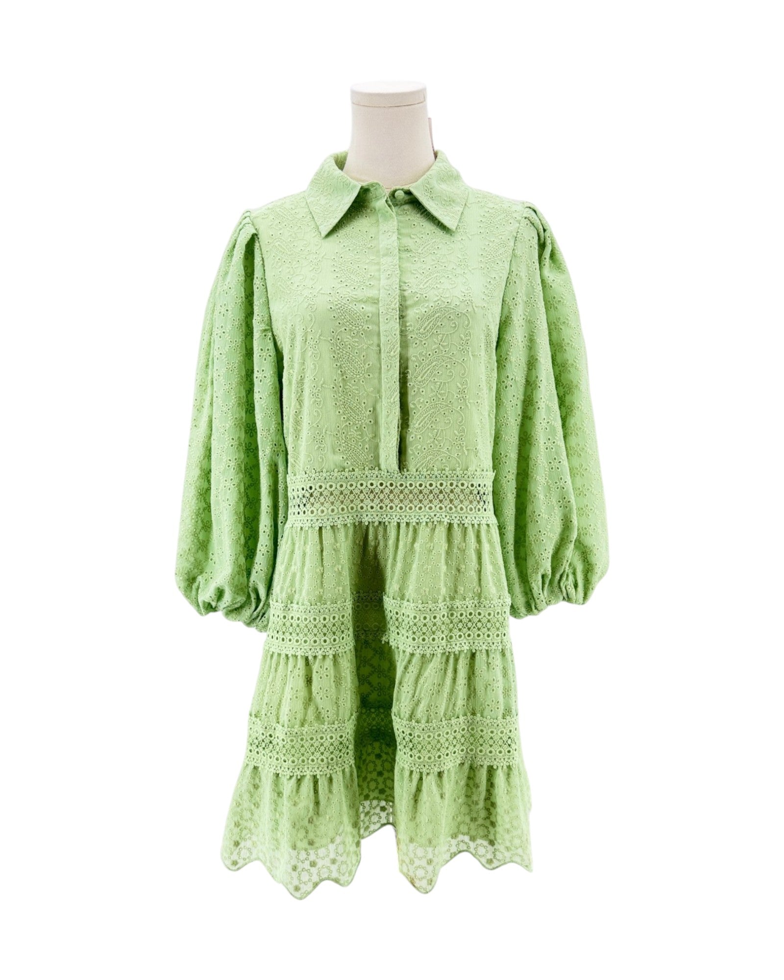 Green dress on a mannequin against a white background