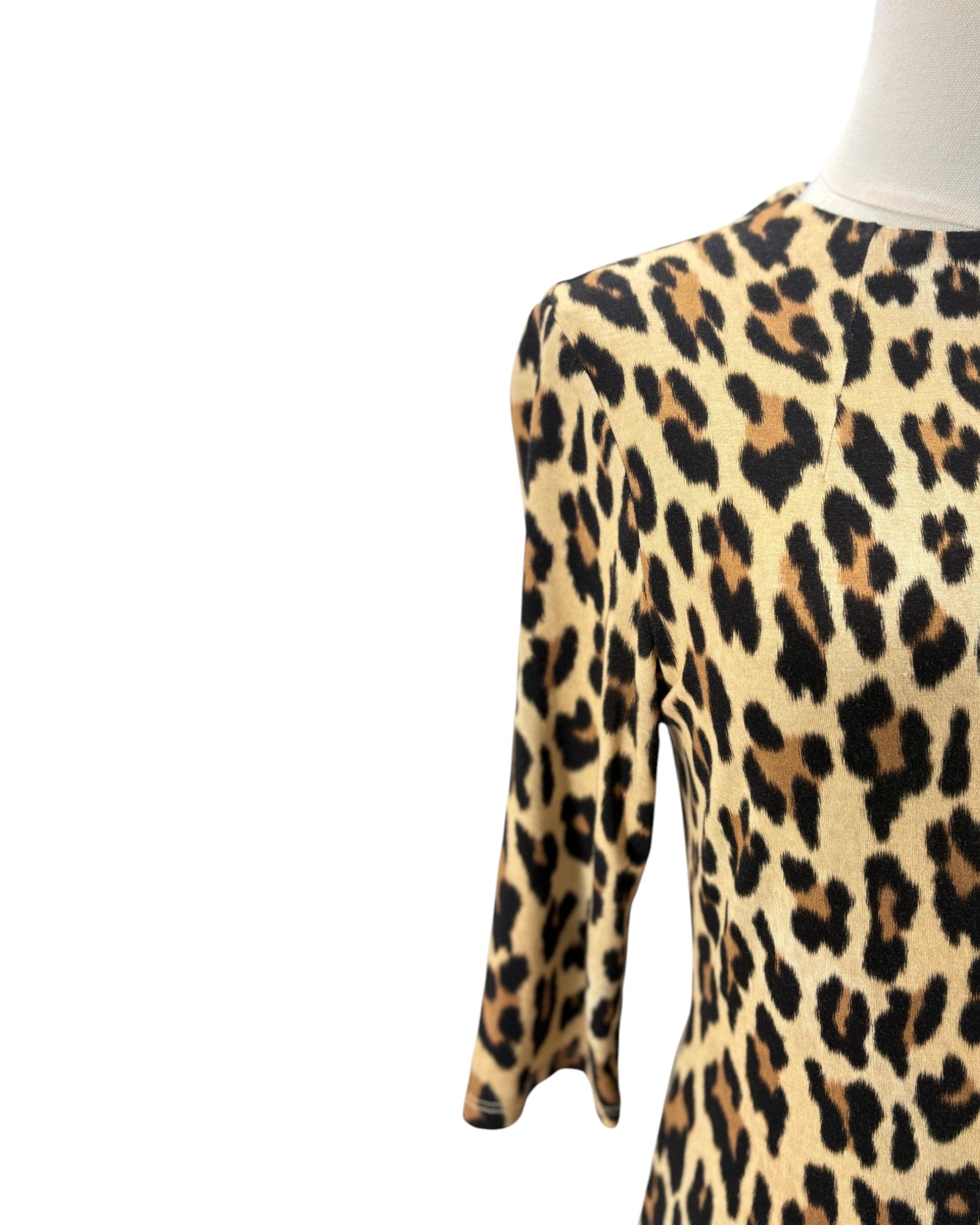 A close-up of a leopard print dress displayed on a mannequin torso against a plain white background.