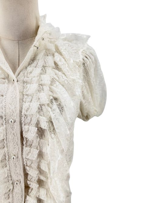 An off-white lace blouse with ruffled details and short puff sleeves, displayed on a mannequin against a plain white background.