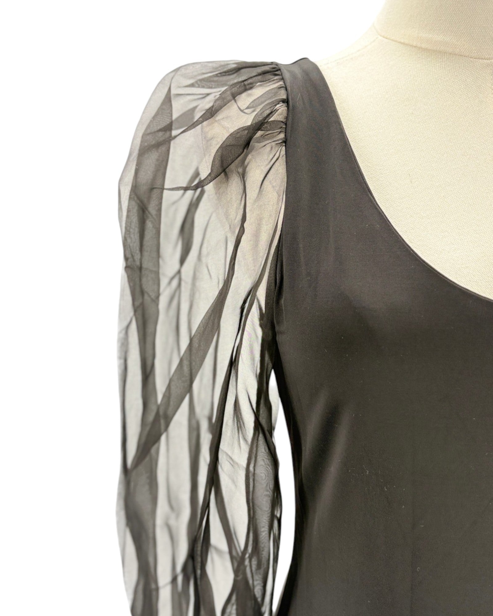 Black puff sleeve bodysuit with sheer black sleeves on a mannequin against a white background