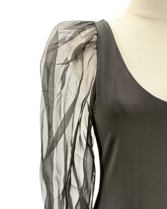 Black puff sleeve bodysuit with sheer black sleeves on a mannequin against a white background