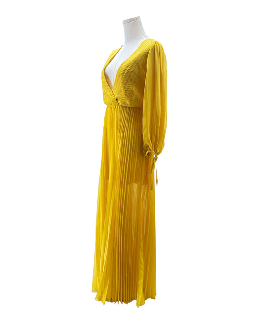 Yellow pleated dress on a mannequin against a white background