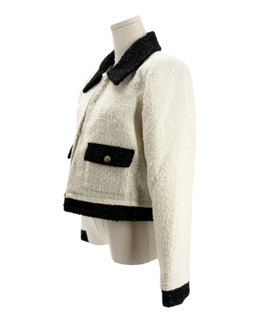 White jacket with black trim on a mannequin against a white background