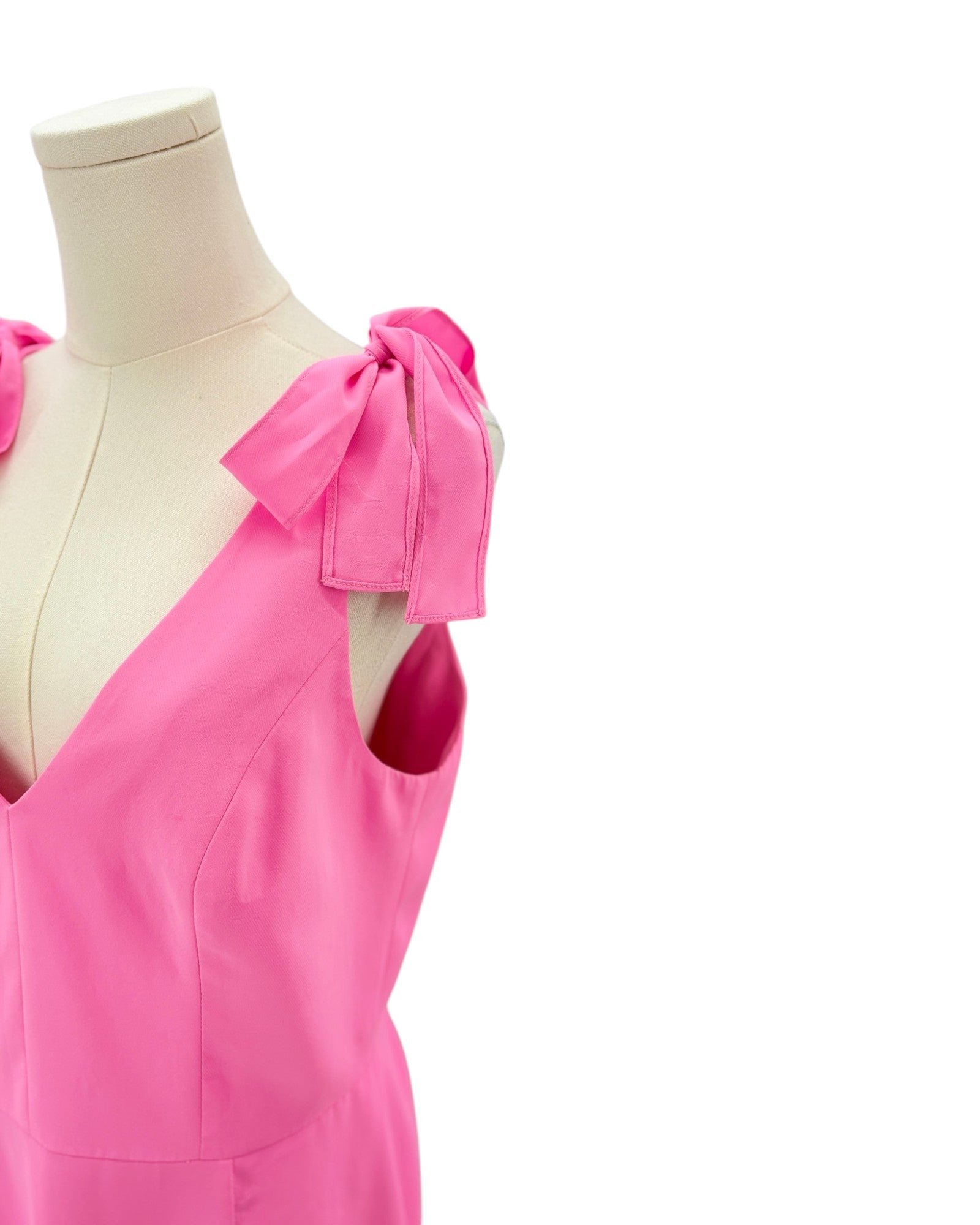 Amanda Uprichard pink dress on a mannequin with bow details against a white background