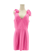 Amanda Uprichard pink dress on a mannequin with bow details against a white background