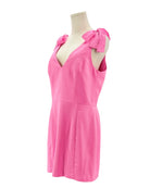 Amanda Uprichard pink dress on a mannequin with bow details against a white background