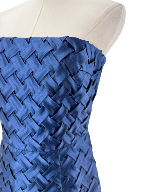 A strapless fitted mini dress with a textured woven pattern, displayed on a cream-colored dress form mannequin against a plain white background.