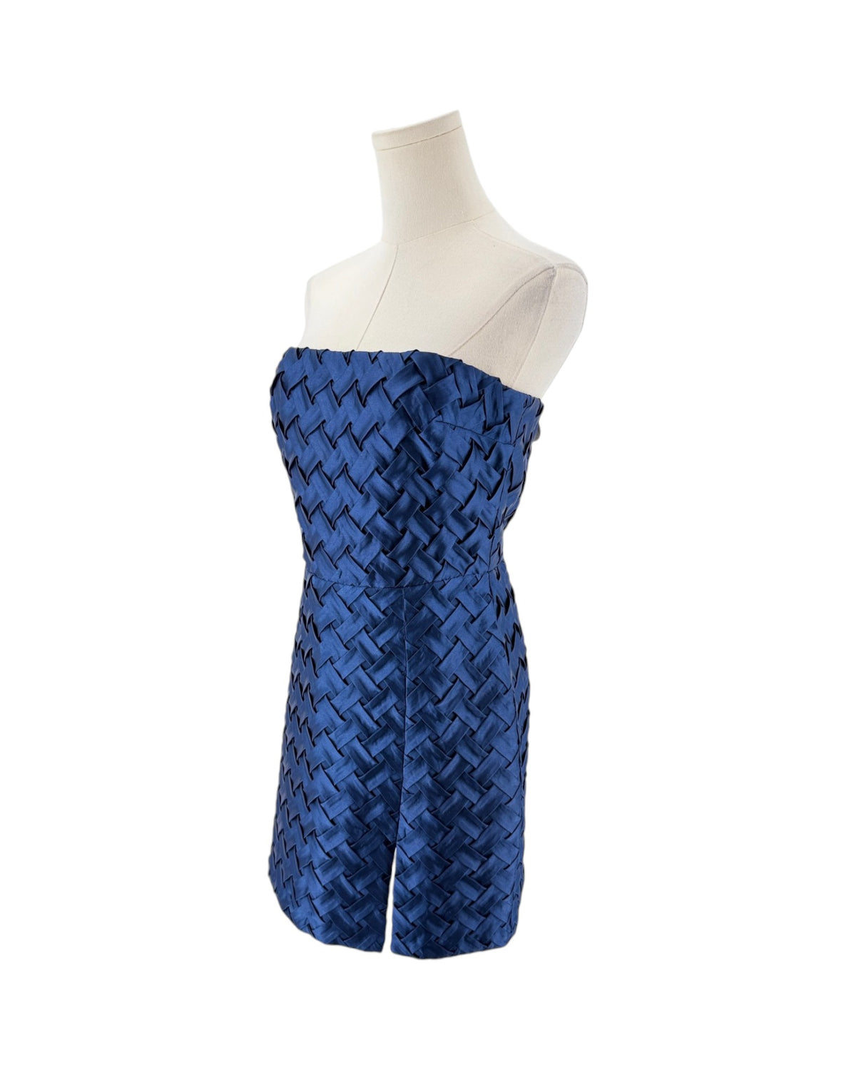 A strapless blue dress with a textured, woven geometric pattern, displayed on a cream-colored mannequin torso against a plain white background.