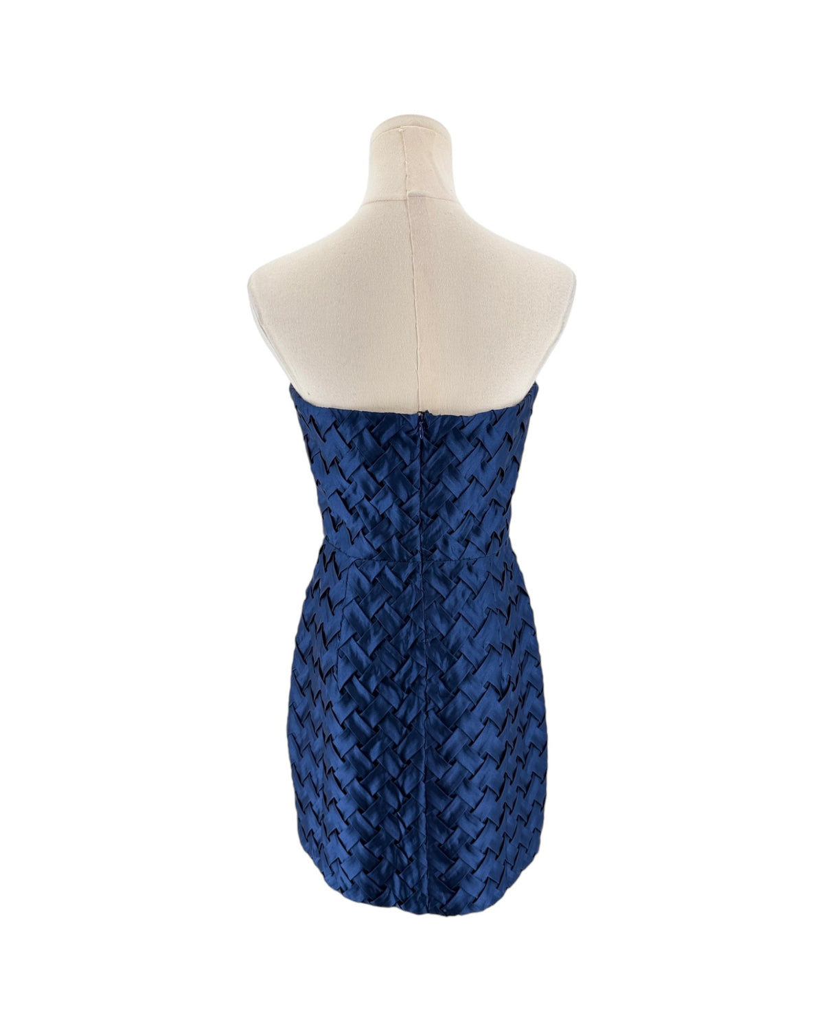 A strapless fitted mini dress with a textured woven pattern, displayed on a cream-colored dress form mannequin against a plain white background.