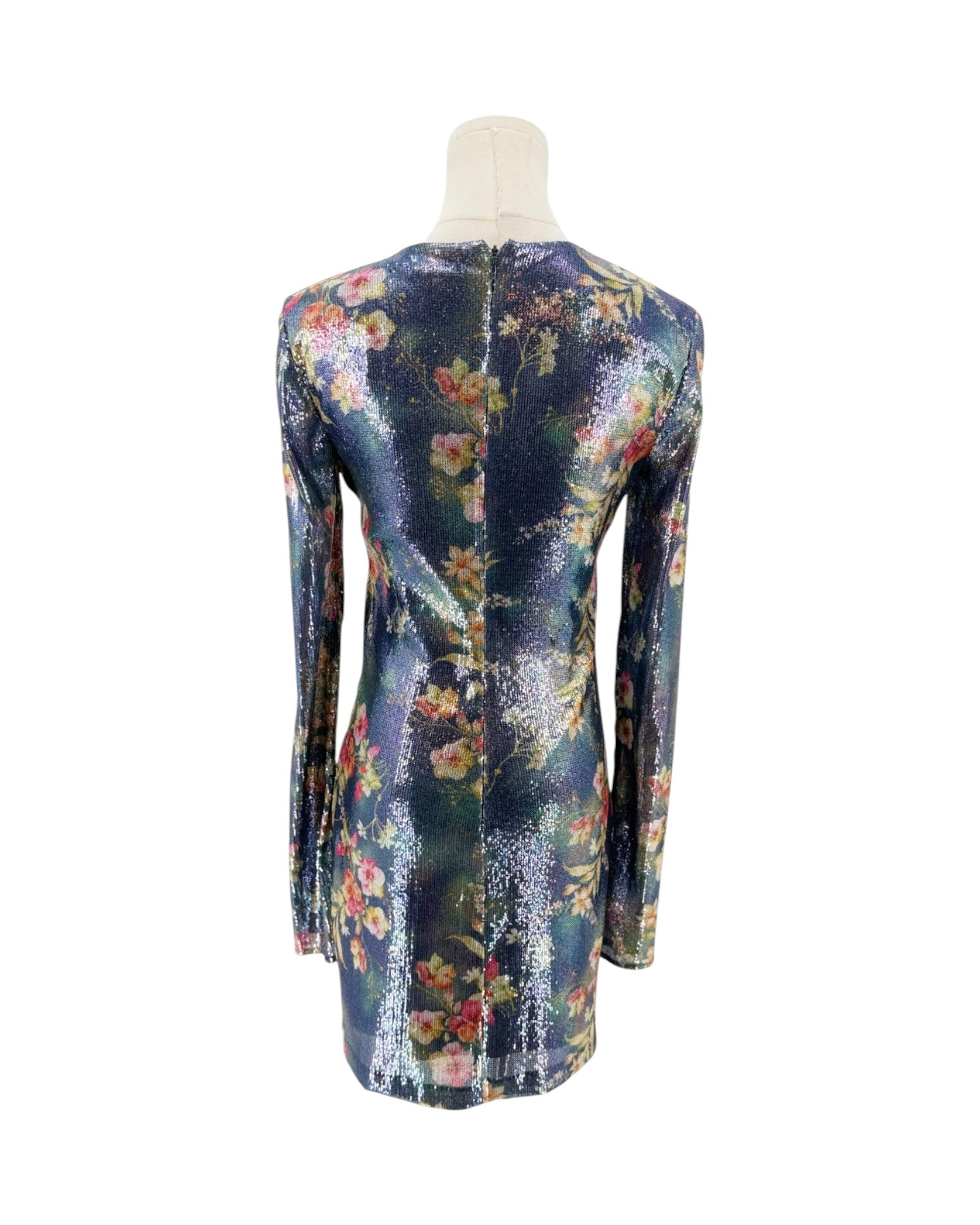 A long-sleeve mini dress with a dense floral print, displayed on a mannequin from the back against a plain white background.
