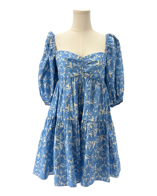 Blue dress with white pattern on a mannequin against a white background