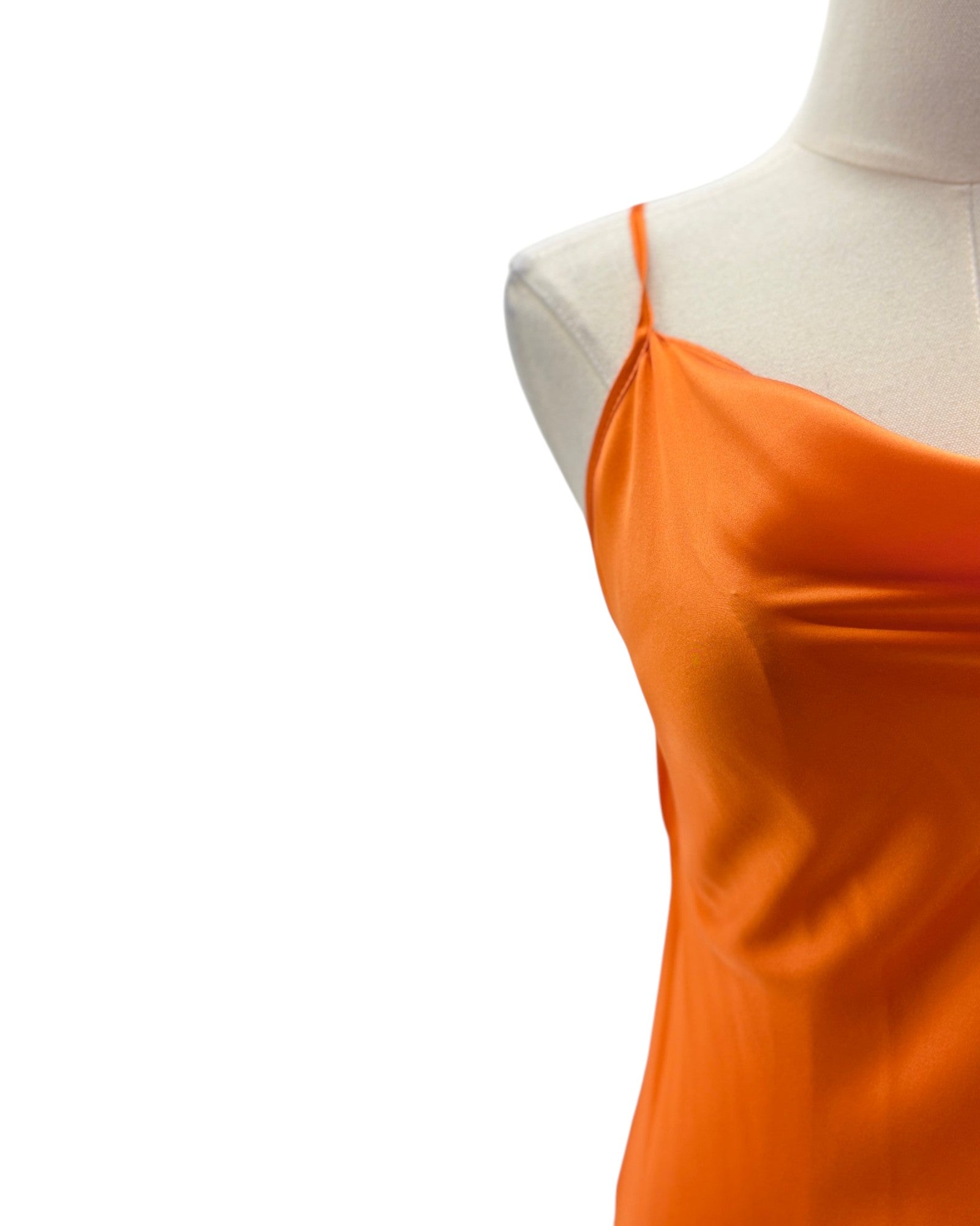 Orange dress on a mannequin against a white background