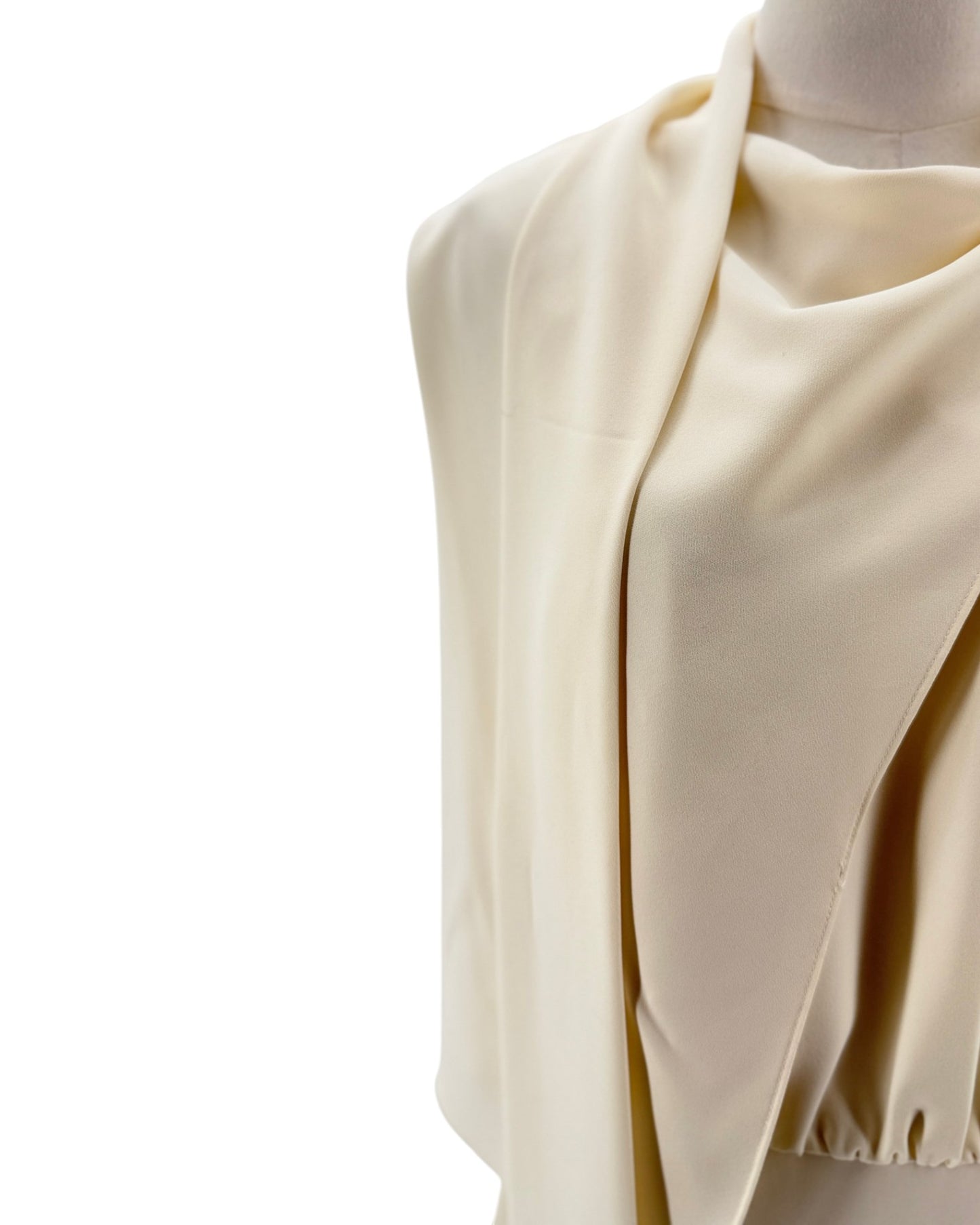 Beige fabric draped over a mannequin on a white background