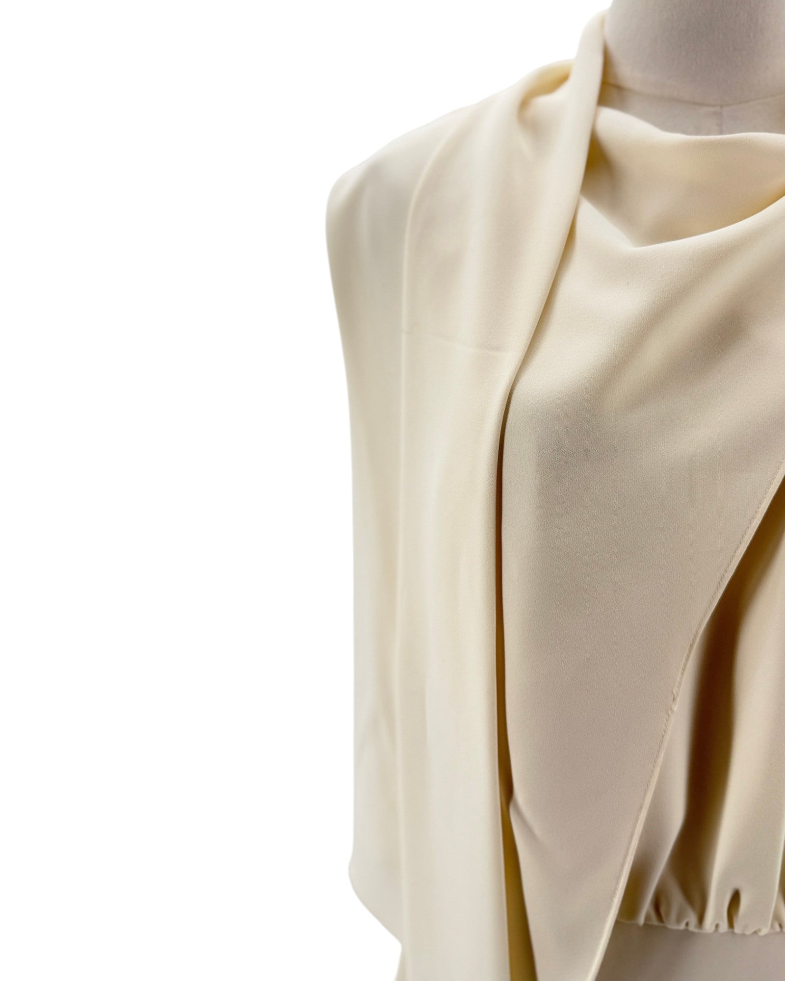 Beige fabric draped over a mannequin on a white background