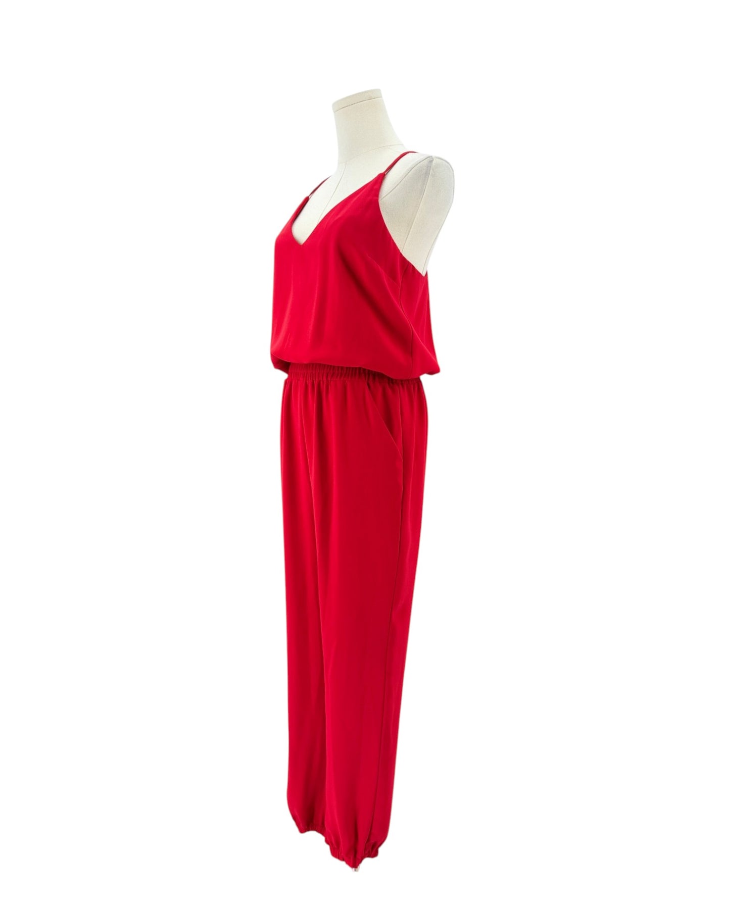 A bright red sleeveless jumpsuit displayed on a white mannequin torso against a plain white background.