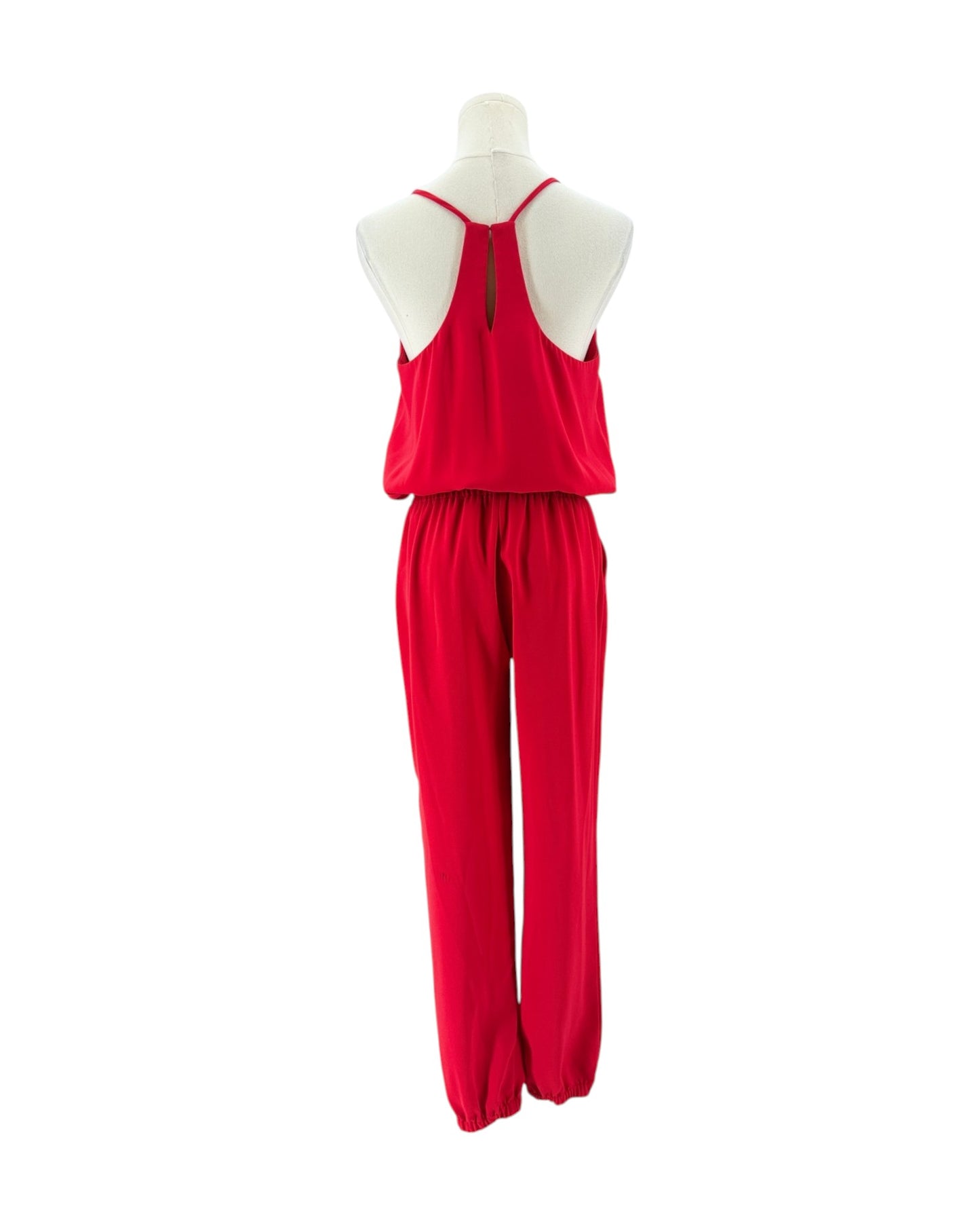 A bright red spaghetti-strap jumpsuit displayed on a cream mannequin torso against a plain white background.