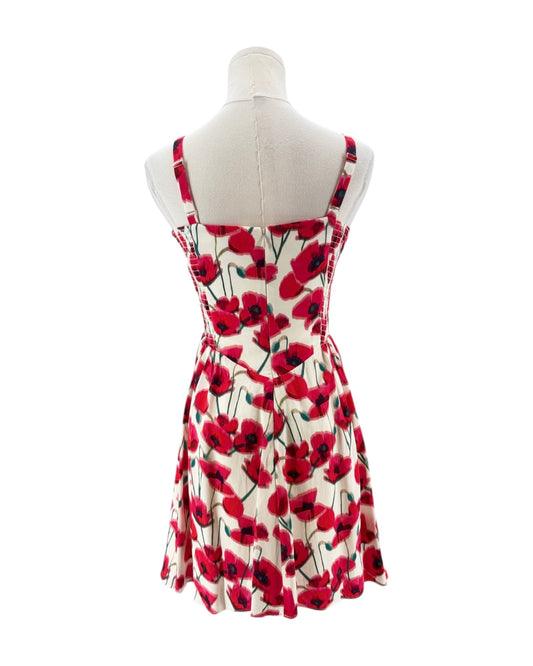 Dress with red floral pattern on a mannequin against a white background