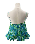 Green and blue patterned top on a mannequin with a white background