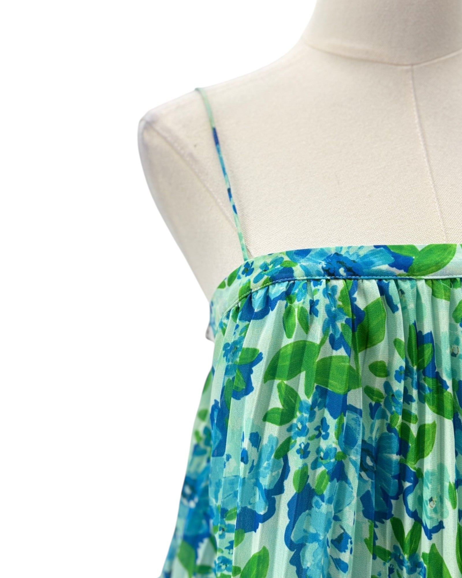 Green and blue floral dress on a mannequin against a white background