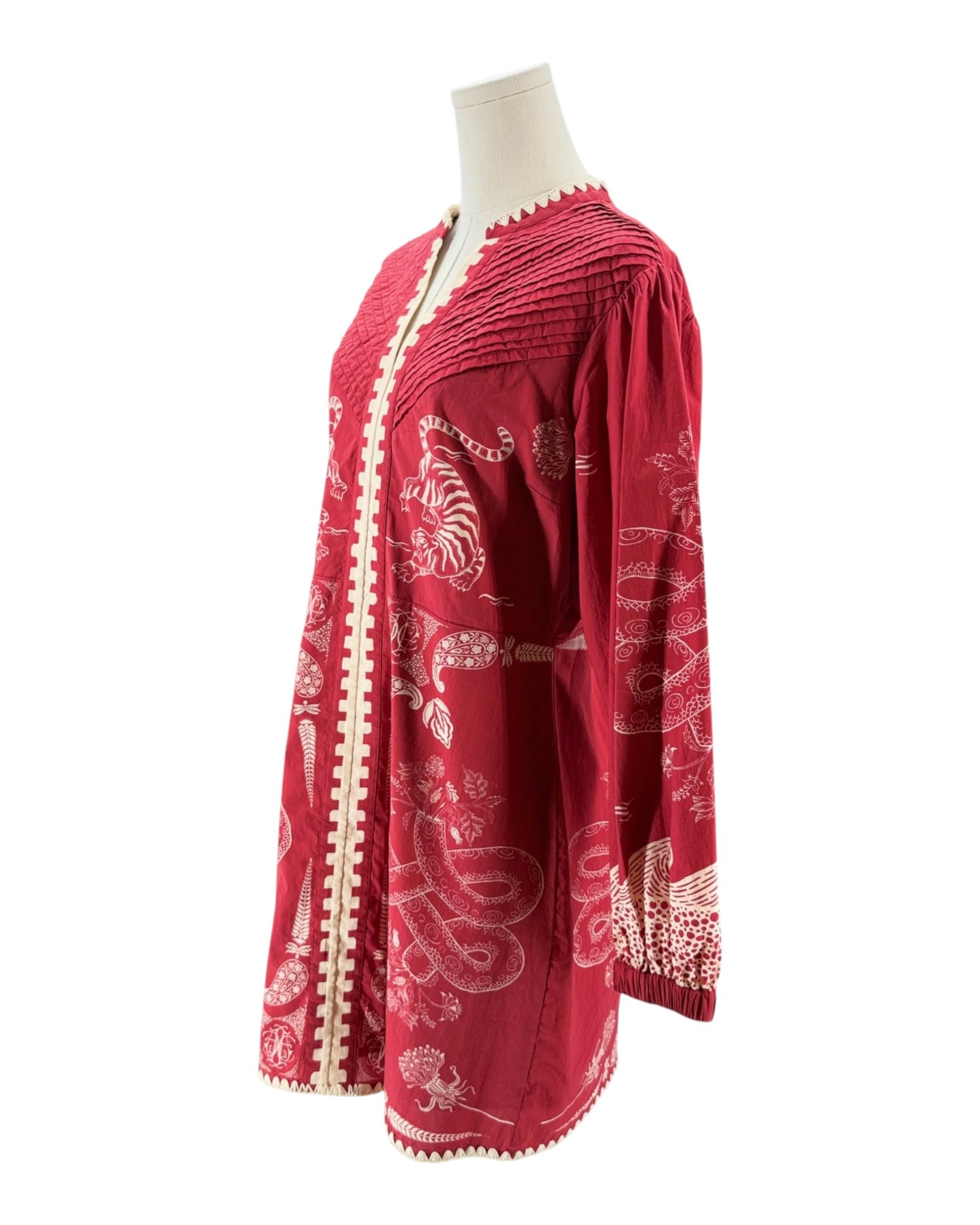 Red garment with white patterns on a mannequin against a white background