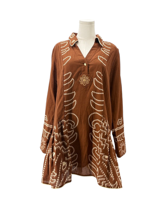 Brown dress with white patterns on a mannequin against a white background