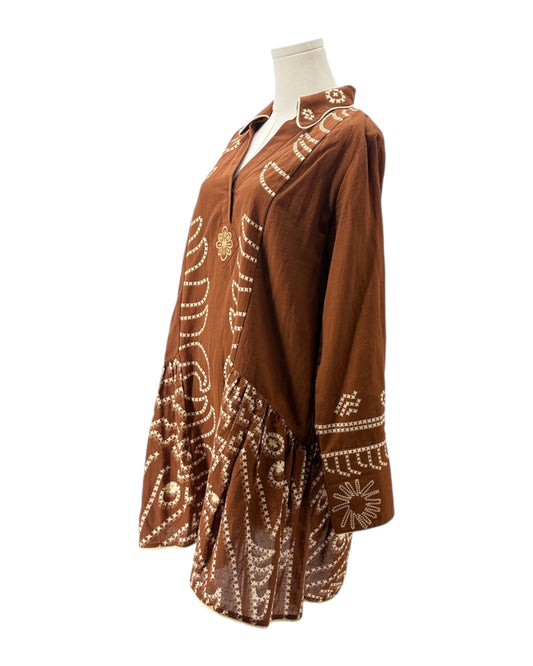 Brown dress with white embroidery on a mannequin against a white background