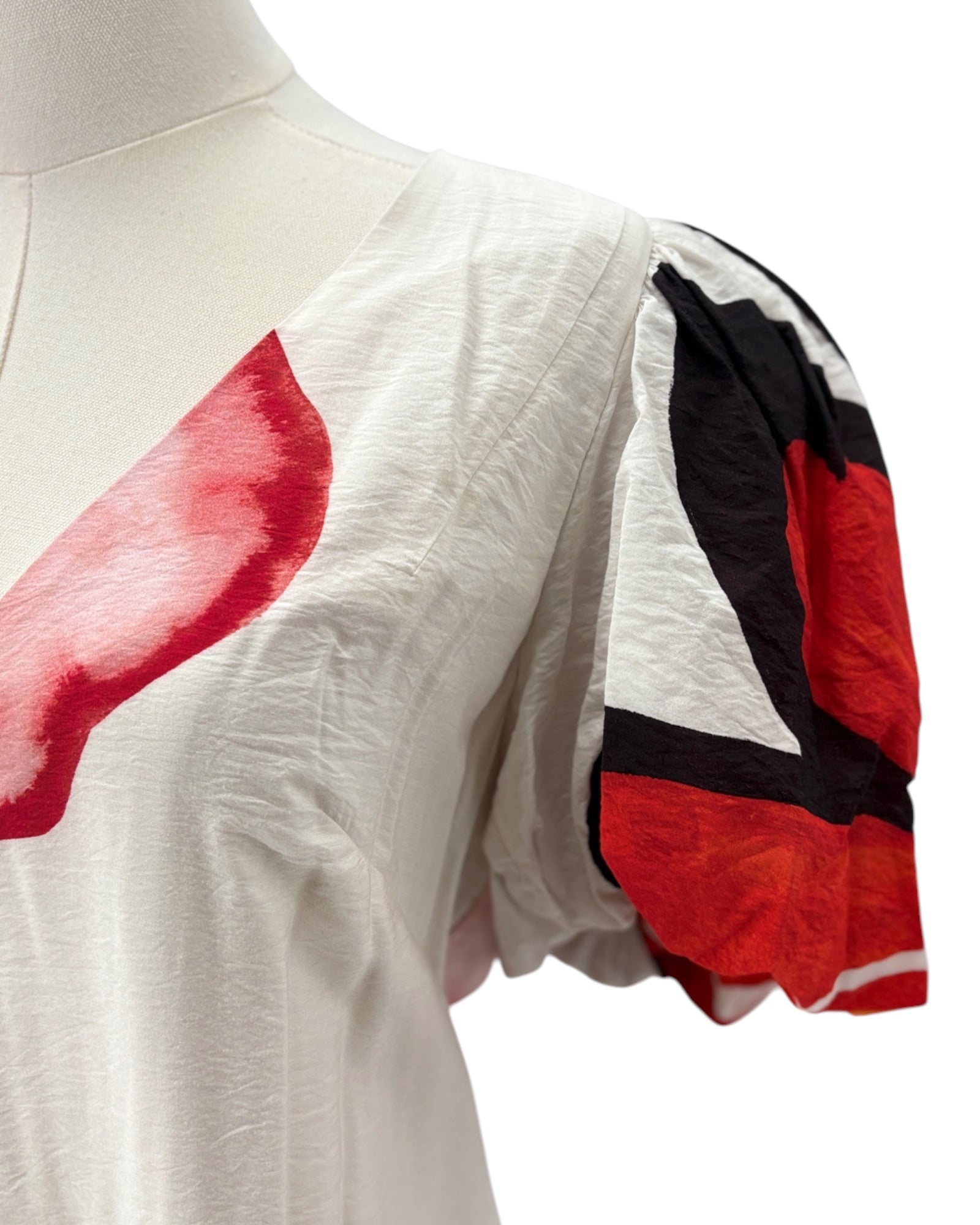 Floral dress with red and black floral patterns on a mannequin against a white background