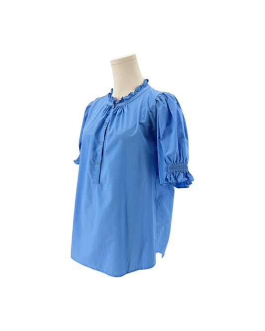 A light blue short-sleeve blouse with ruffled trim at the collar and cuffs, displayed on a cream mannequin torso against a plain white background.