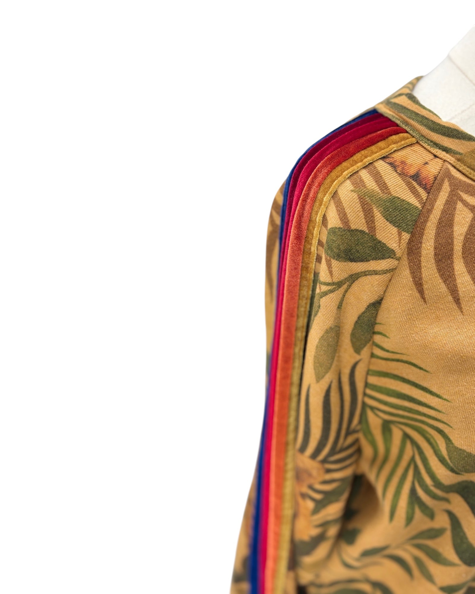 Close-up of a garment with a colorful sleeve and leaf pattern on a white background