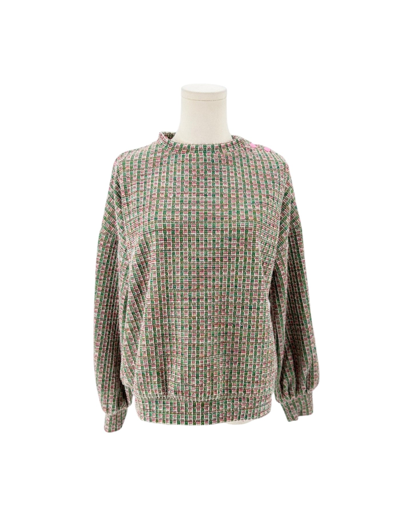 A long-sleeve knit sweater with a textured, woven grid pattern in muted green, pink, and beige tones, displayed on a white mannequin torso against a plain white background.