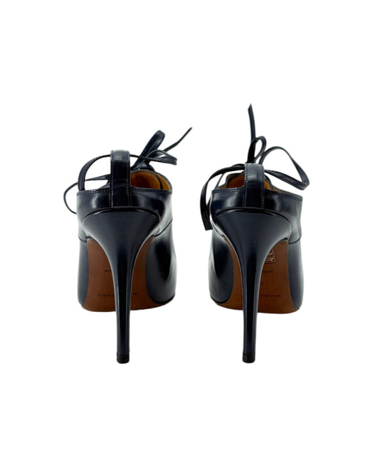 Black high-heeled shoes with brown soles on a white background