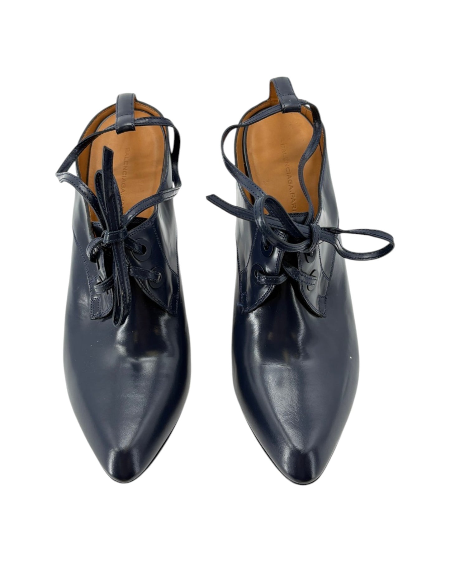 Pair of navy leather shoes with brown soles on a white background
