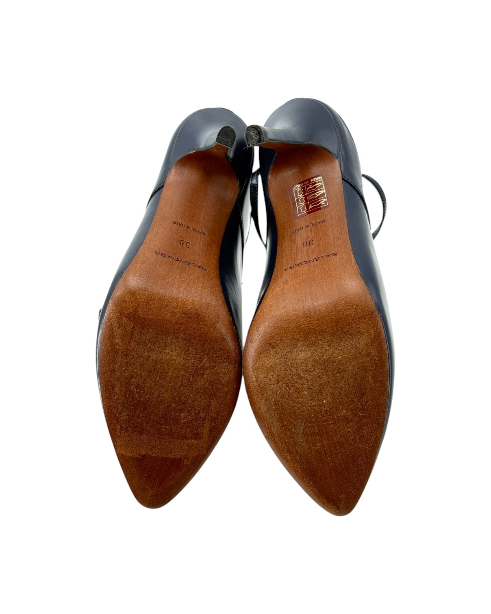 Pair of navy shoes with brown soles on a white background