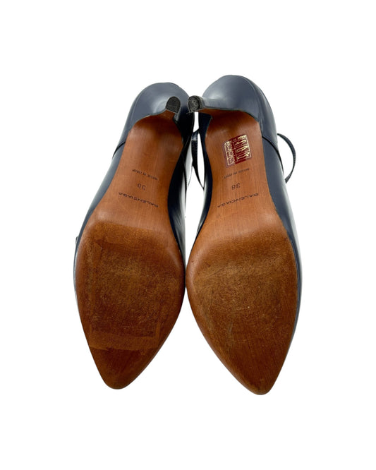 Pair of navy shoes with brown soles on a white background