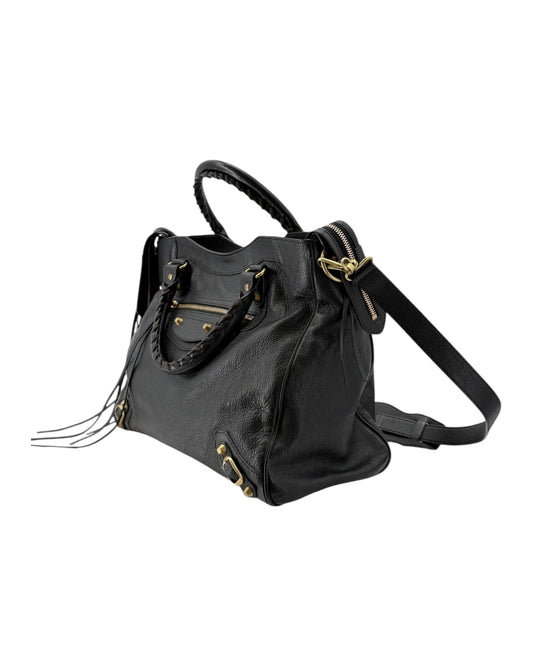 Black leather handbag with gold accents on a white background