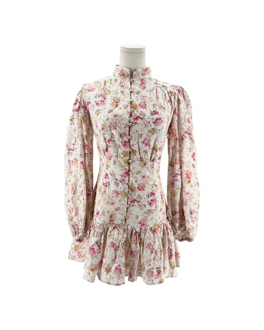 A vintage-style floral dress displayed on a mannequin torso against a plain white background. The long-sleeve dress features a high ruffled collar, button-front closure, and a ruffled hem.