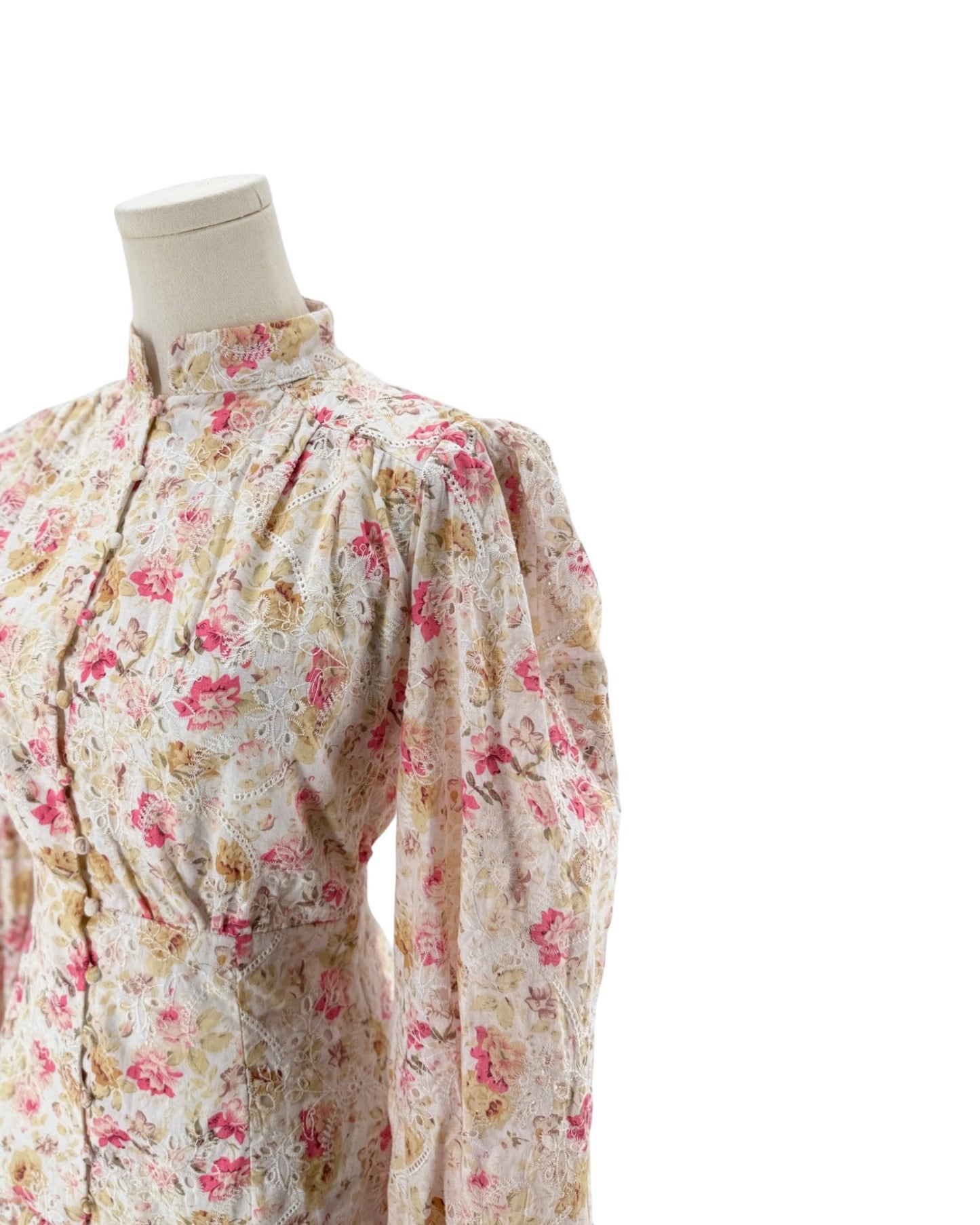 A vintage floral print long-sleeve dress displayed on a cream-colored mannequin torso against a solid white backgro.und