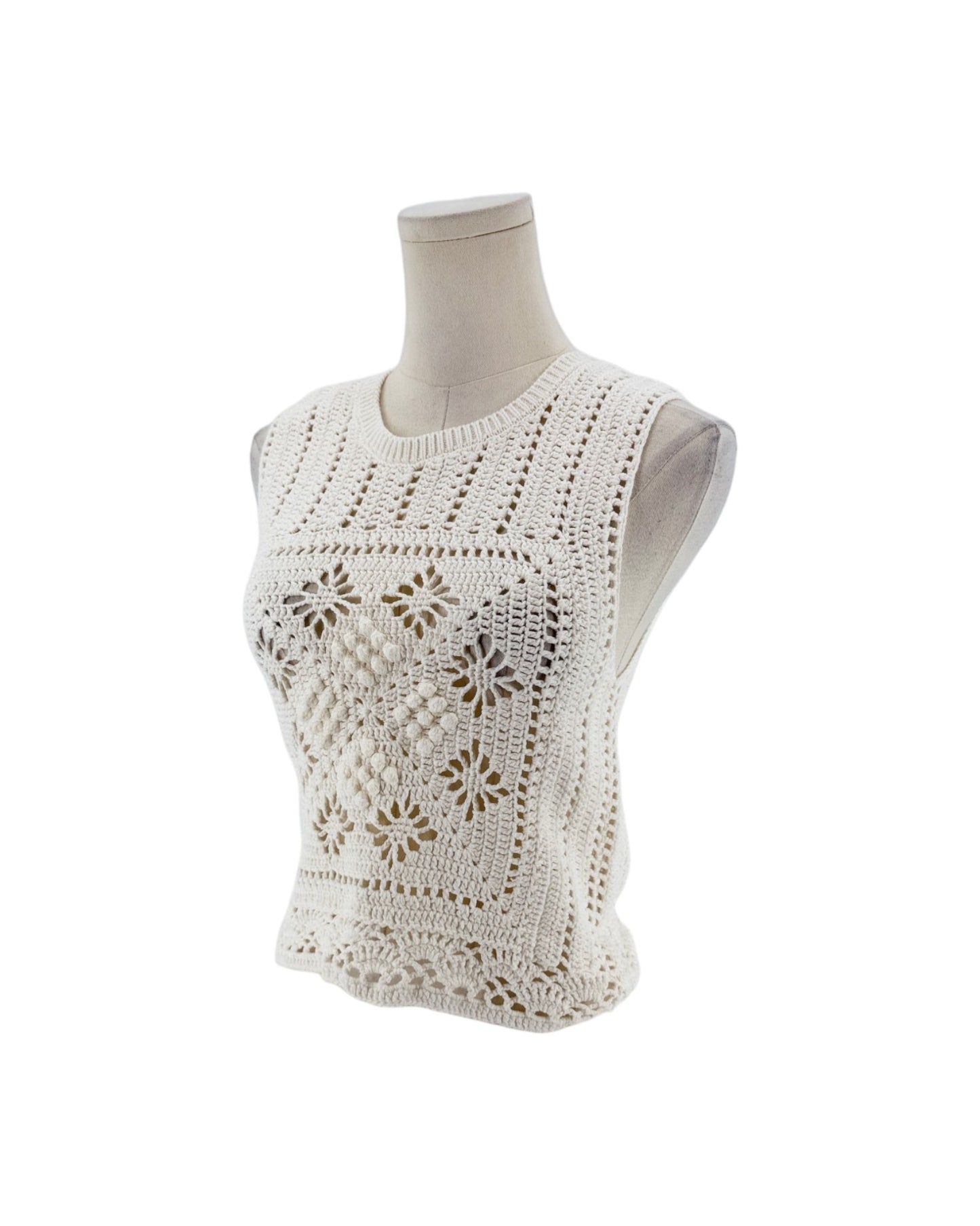 Sleeveless crochet top on a white background on a mannequin.