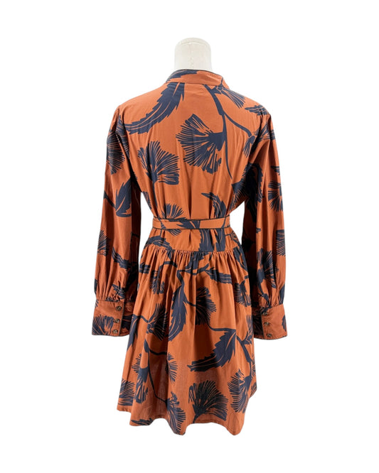 Orange dress with black leaf pattern on a mannequin against a white background