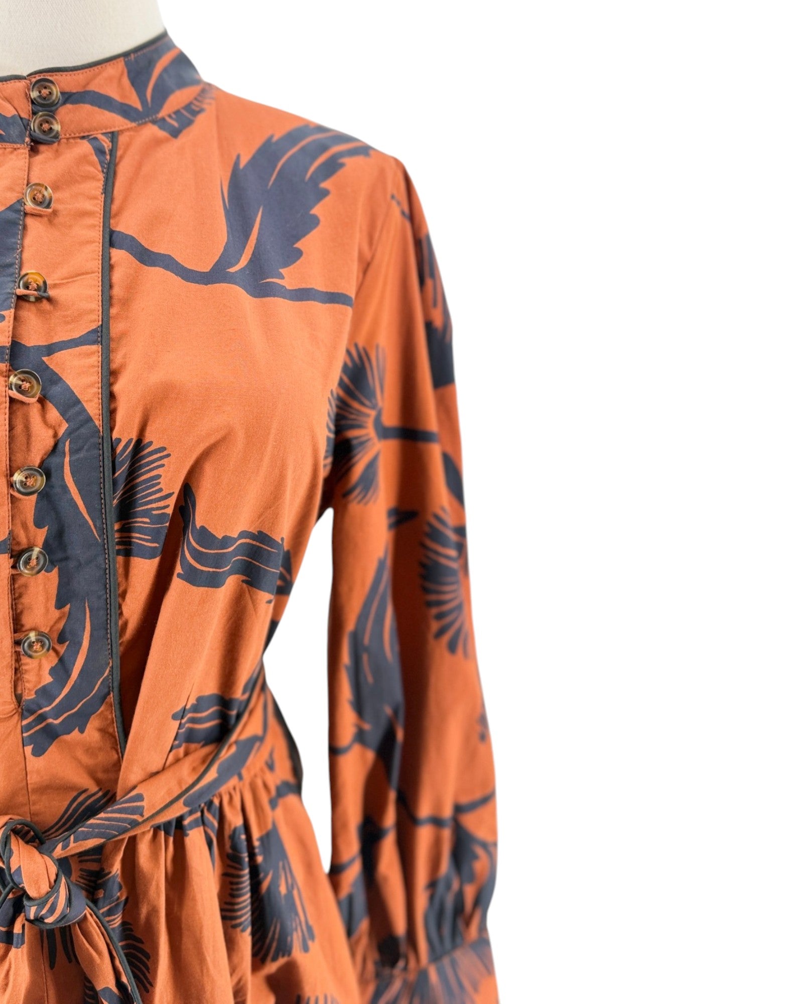 Orange dress with black floral patterns on a white background