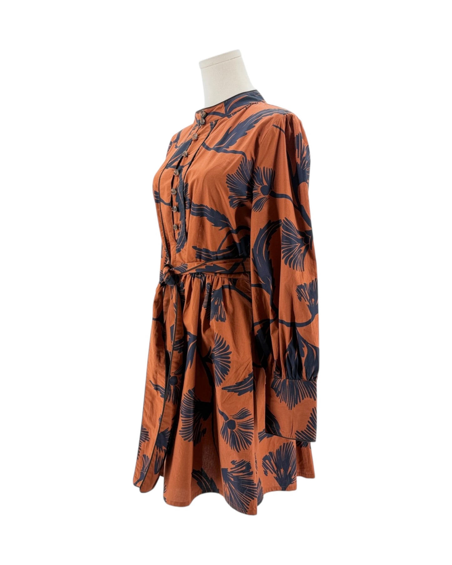 Orange dress with black pattern on a mannequin against a white background