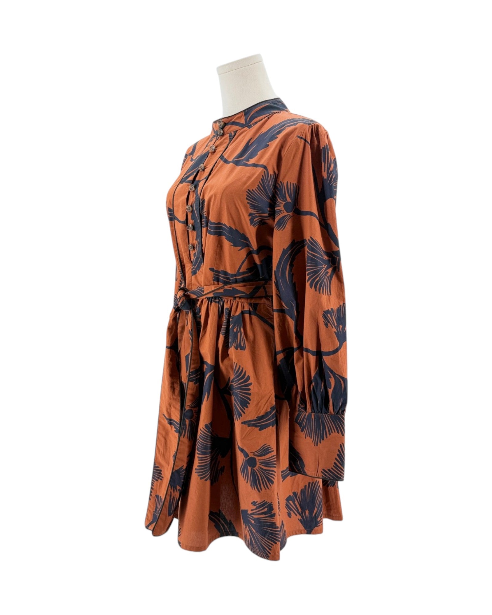 Orange dress with black pattern on a mannequin against a white background
