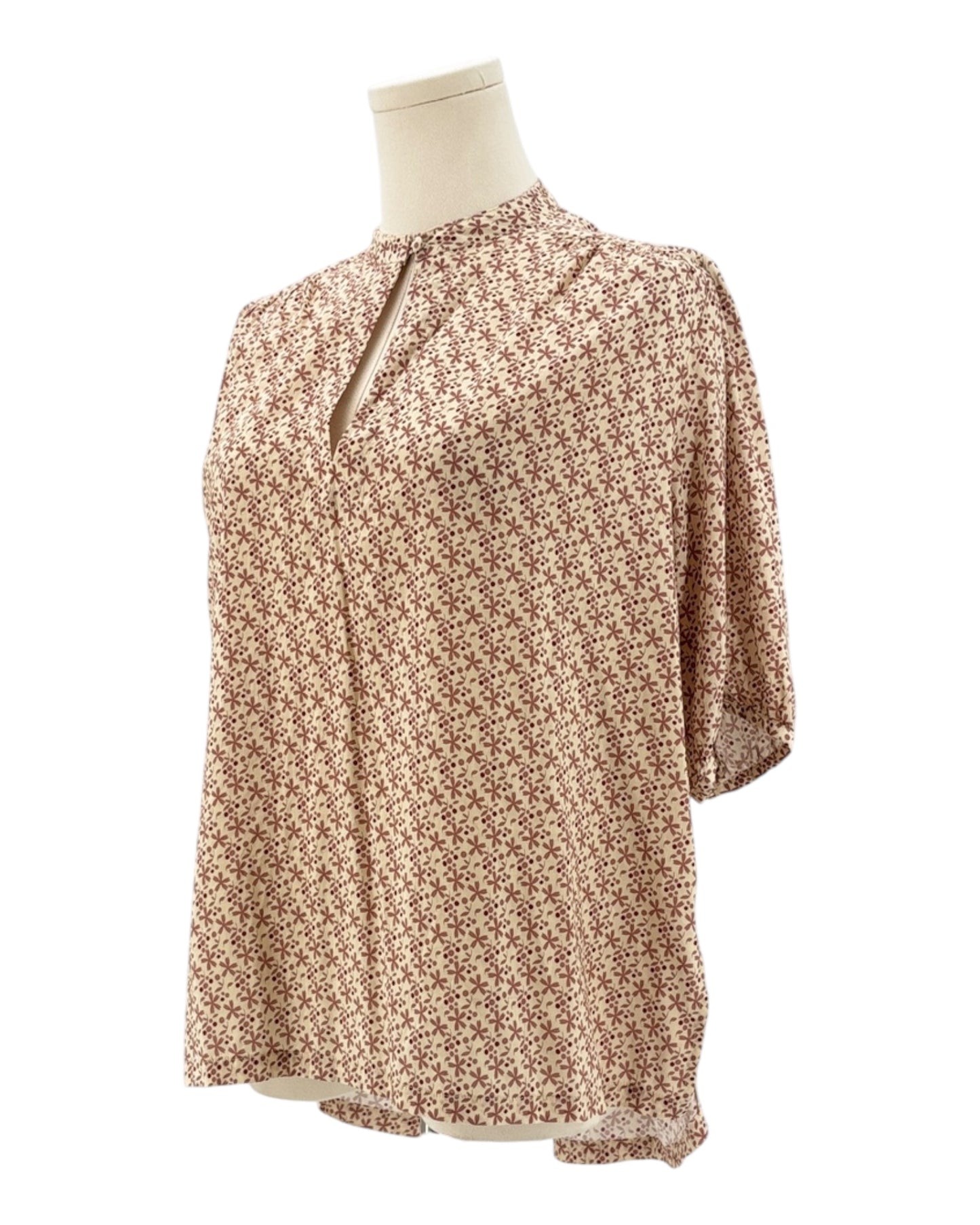 Floral blouse on a mannequin against a white background