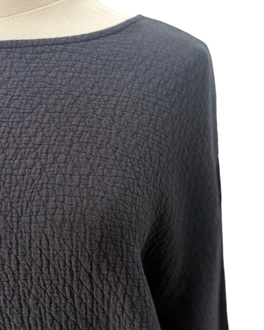 Blacktextured sweater on a mannequin against a white background