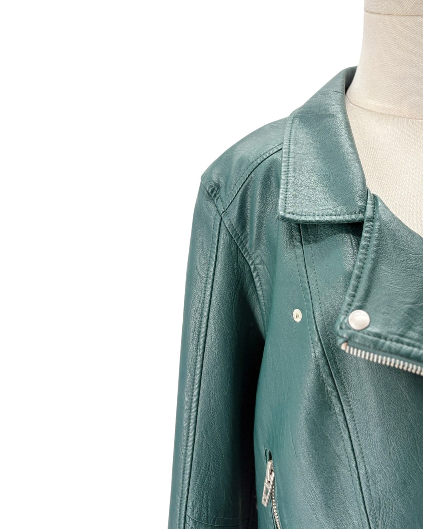 A close-up of a teal green faux leather motorcycle jacket displayed on a cream mannequin torso against a plain white background.