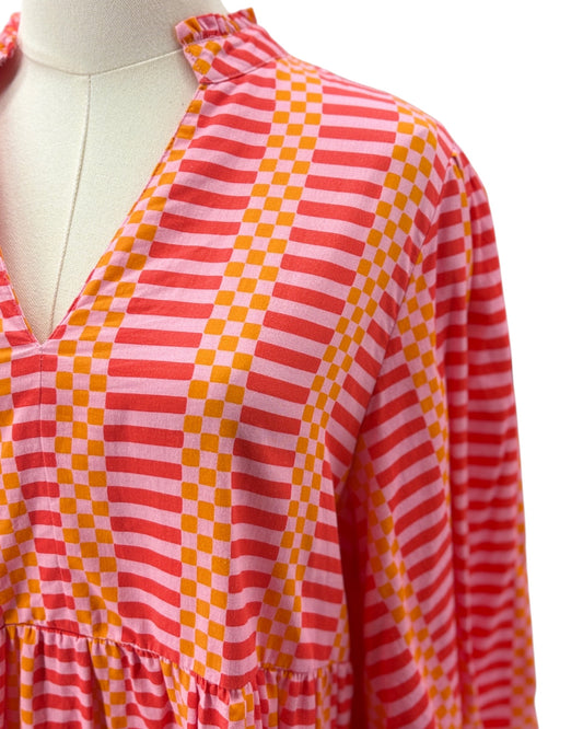 Mannequin wearing a pink and orange checkered dress on a white background
