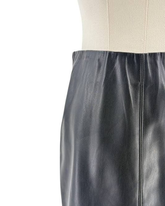 Close-up of a black leather skirt with a white background