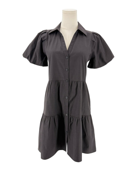 A balck short-sleeve button-front dress displayed on a cream mannequin torso against a plain white background.